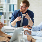 Young businessman listening to his colleague explanations and looking at him