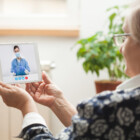 Elderly caucasian woman talking to young female e-doctor via online video chat,medical worker seeing patient in virtual house call,telemedicine during pandemic,on demand home medical service concept || Modellfreigabe vorhanden