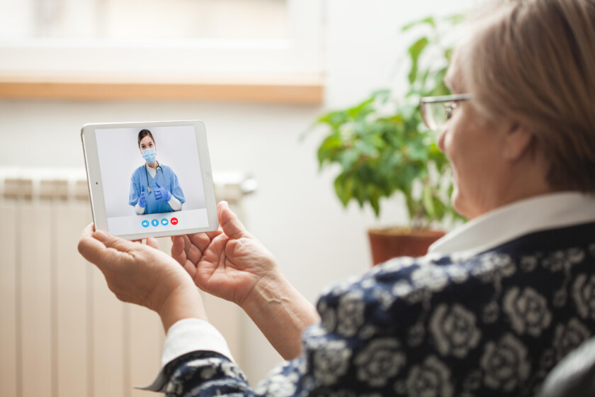 Elderly caucasian woman talking to young female e-doctor via online video chat,medical worker seeing patient in virtual house call,telemedicine during pandemic,on demand home medical service concept || Modellfreigabe vorhanden