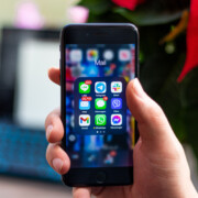 Person opens up iPhone to look at apps while on their laptop