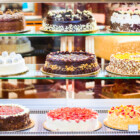 Pastry shop glass display with selection of cream or fruit cake