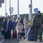 A Polish border guard assists refugees from Ukraine as they arrive to Poland at the Korczowa border crossing, Poland, Saturday, Feb. 26, 2022. (AP Photo/Czarek Sokolowski)