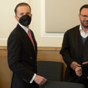 Hendrik Holt (l) steht im Sitzungssaal vom Landgericht neben seinen Verteidigern Maximilian Pancic (2.v.r) und Marco Lund (r). Prozess um Windkraftbetrugsvorwürfe