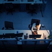 Working Late at Night in the Office: Businesswoman Using Desktop Computer, Analyzing, Using Documents, Solving Problems, Finishing Project. High Angle Shot