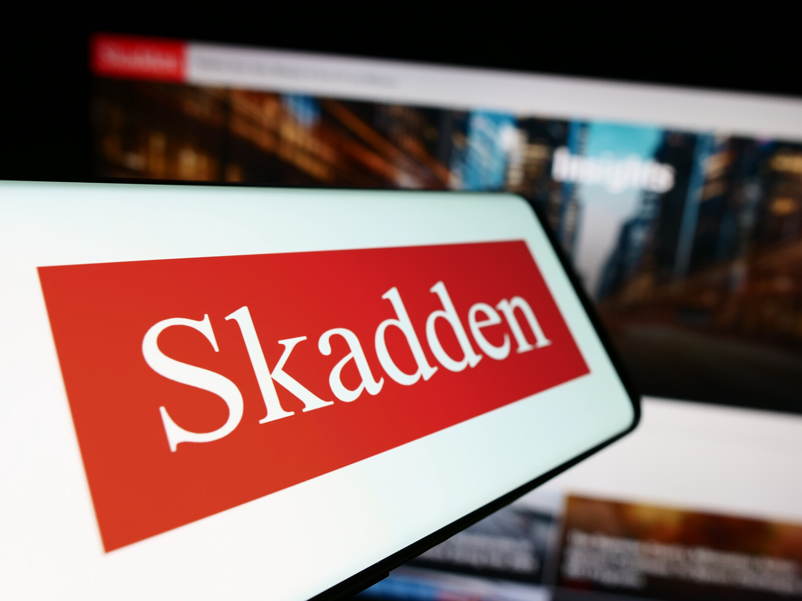 Stuttgart, Germany - 12-17-2023: Smartphone with logo of American law firm Skadden, Arps, Slate, Meagher and Flom LLP in front of website. Focus on center-left of phone display.