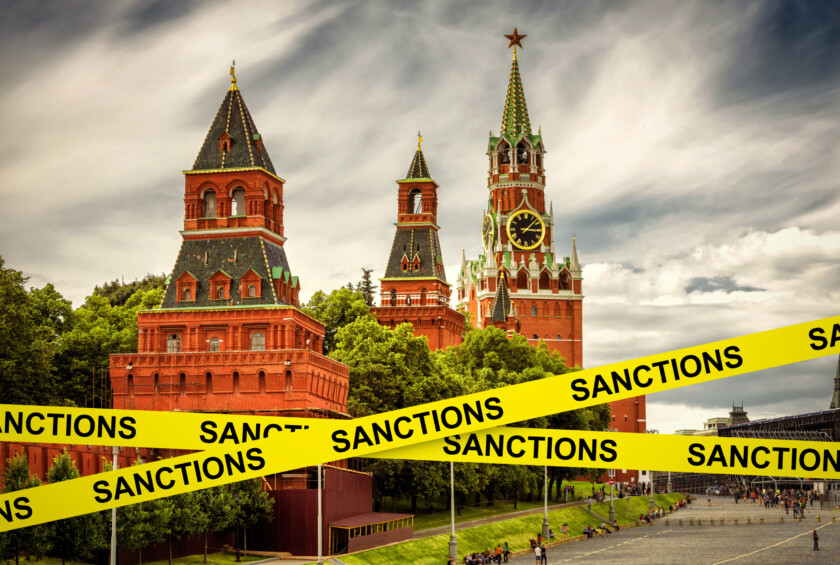 Sanctions caution tape at Moscow, Russia. Warning information on Kremlin background. Concept of economic sanctions against Russia, world crisis, Russian economy, politics, tension and geopolitics.