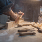 Handmade concept. Women's hands do the product of wood. Wood workshop with a tool and a lamp