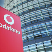 Düsseldorf (Vodafone campus) - March 9. 2022: View on red pillar against futuristic building tower and blue sky, fluffy clouds
