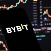 KYIV, UKRAINE - MARCH 15, 2024 Bybit logo on iPhone display screen and crypto currency value charts. Cryptocurrency exchange portal