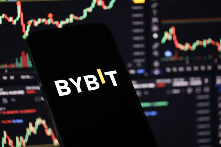 KYIV, UKRAINE - MARCH 15, 2024 Bybit logo on iPhone display screen and crypto currency value charts. Cryptocurrency exchange portal
